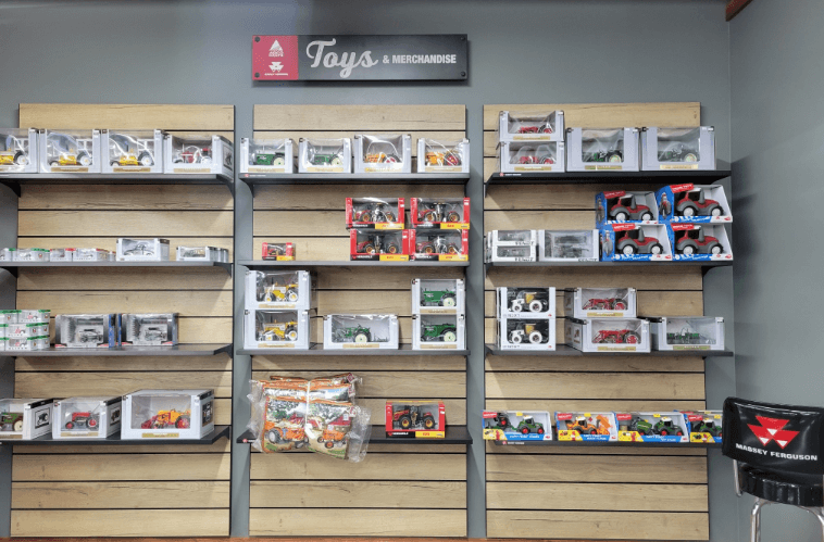 Large toy grey and red tractors lined up on Toys shelf